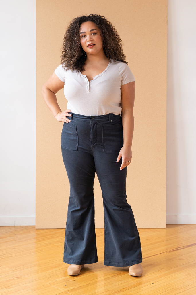 A woman wearing a shirt and flared jeans
