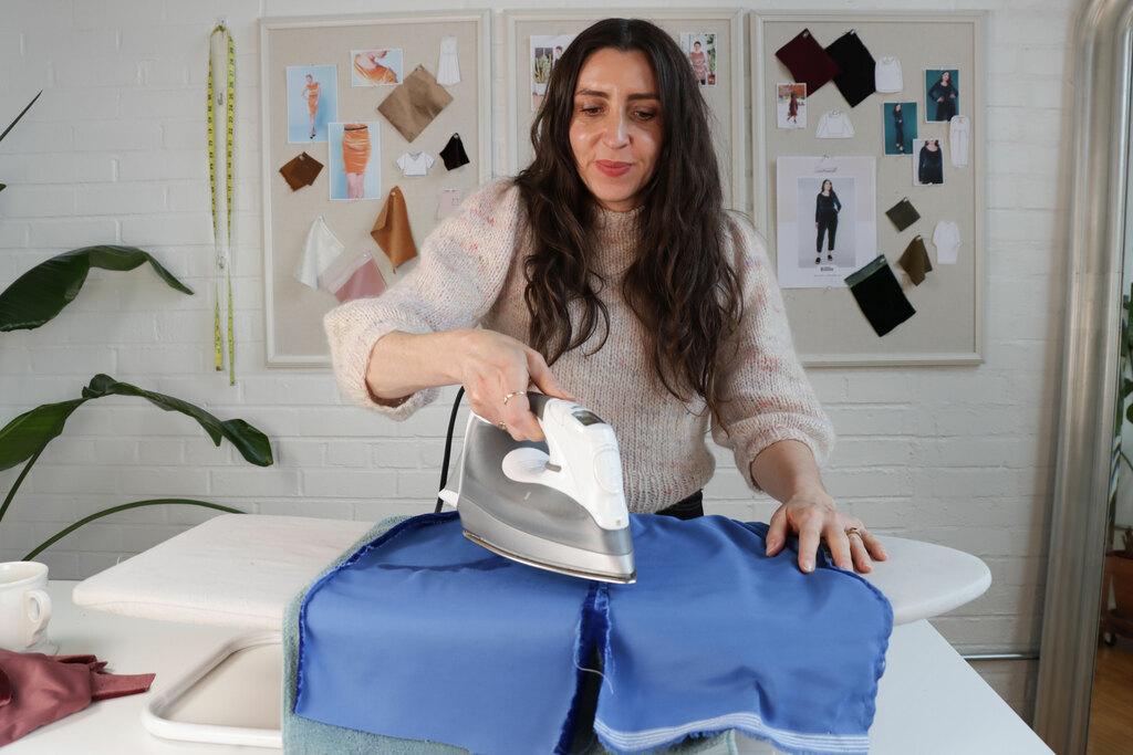 Sarai ironing a piece of velvet over a towel
