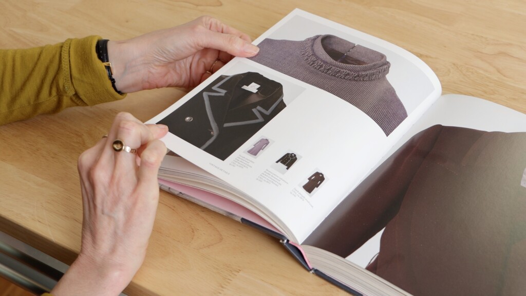 Open vintage sewing book showing detailed coat construction techniques