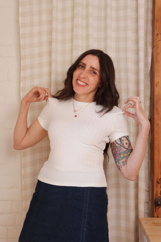 Flat lay of a finished white pointelle Morgan tee on a neutral background