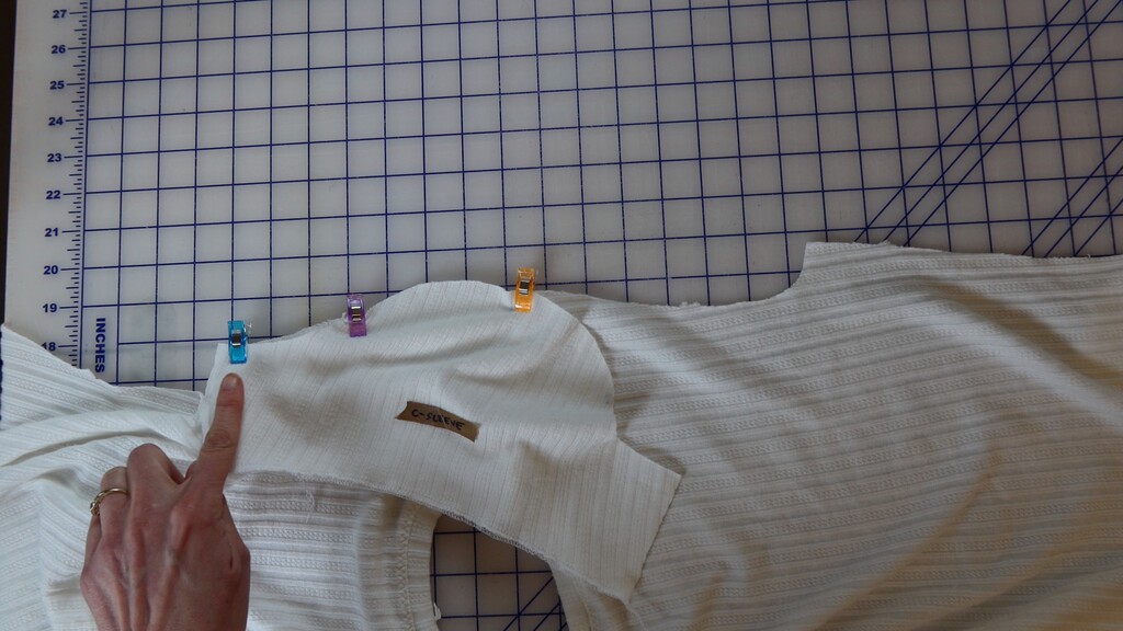 Sleeve being set into armhole, starting from the center circle at the shoulder seam and stitching outward in each direction